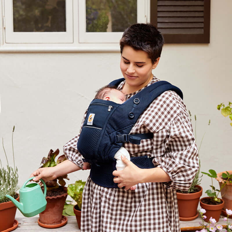 Ergobaby Adapt - SoftFlex Mesh: Midnight Blue baby carrier with a mother holding a baby and watering can | Babymaxi
