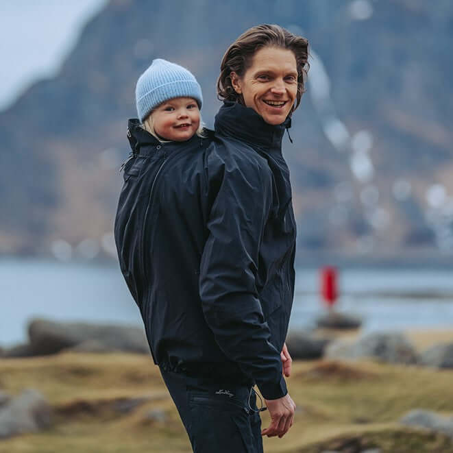 Mamalila Explorer Dad Waterproof Babywearing Shell Jacket - Black in use by father with baby outdoors | Babymaxi