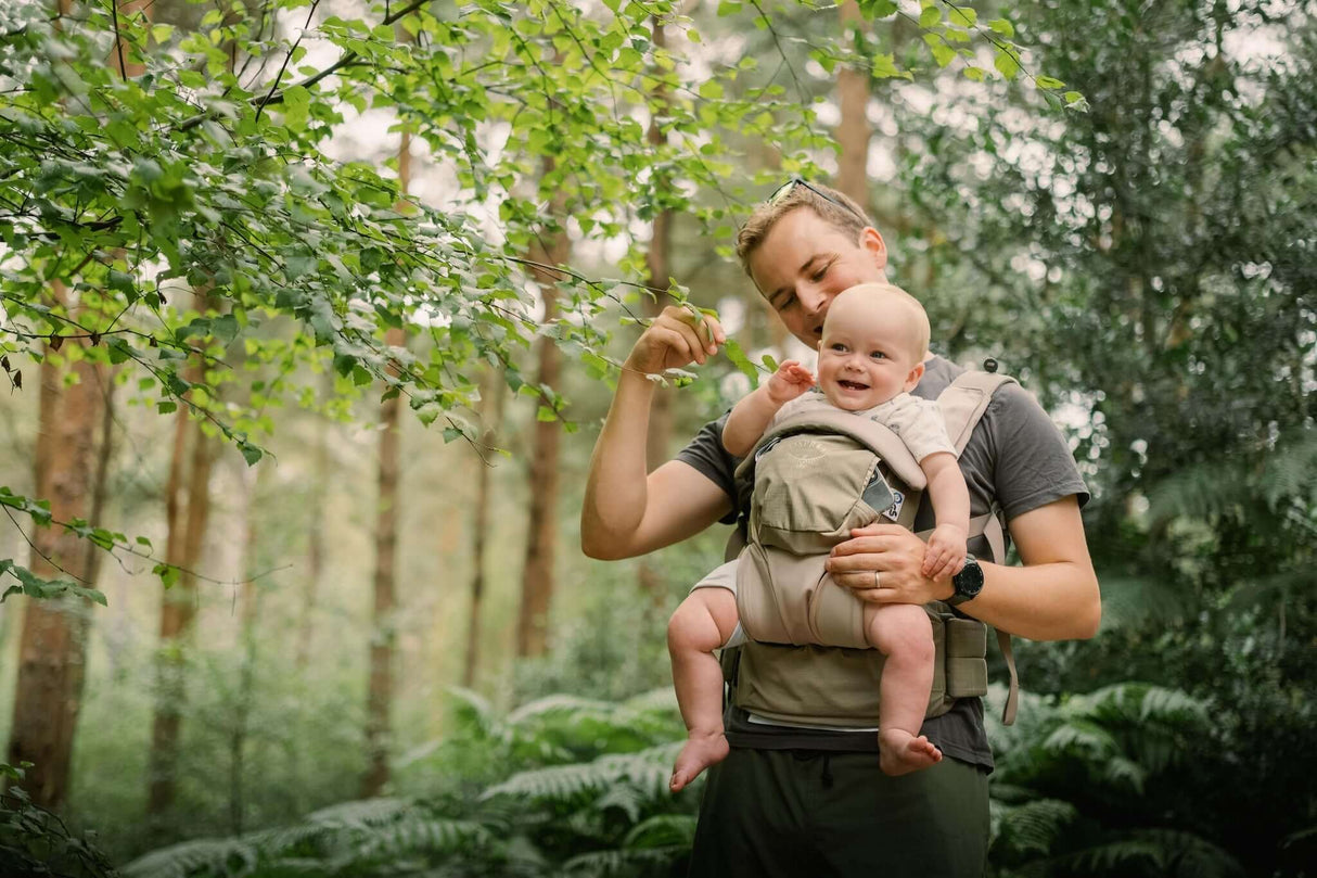 Osprey Poco Soft Child Carrier LT - Tan Concrete in use by a parent in a forest with happy baby | Babymaxi