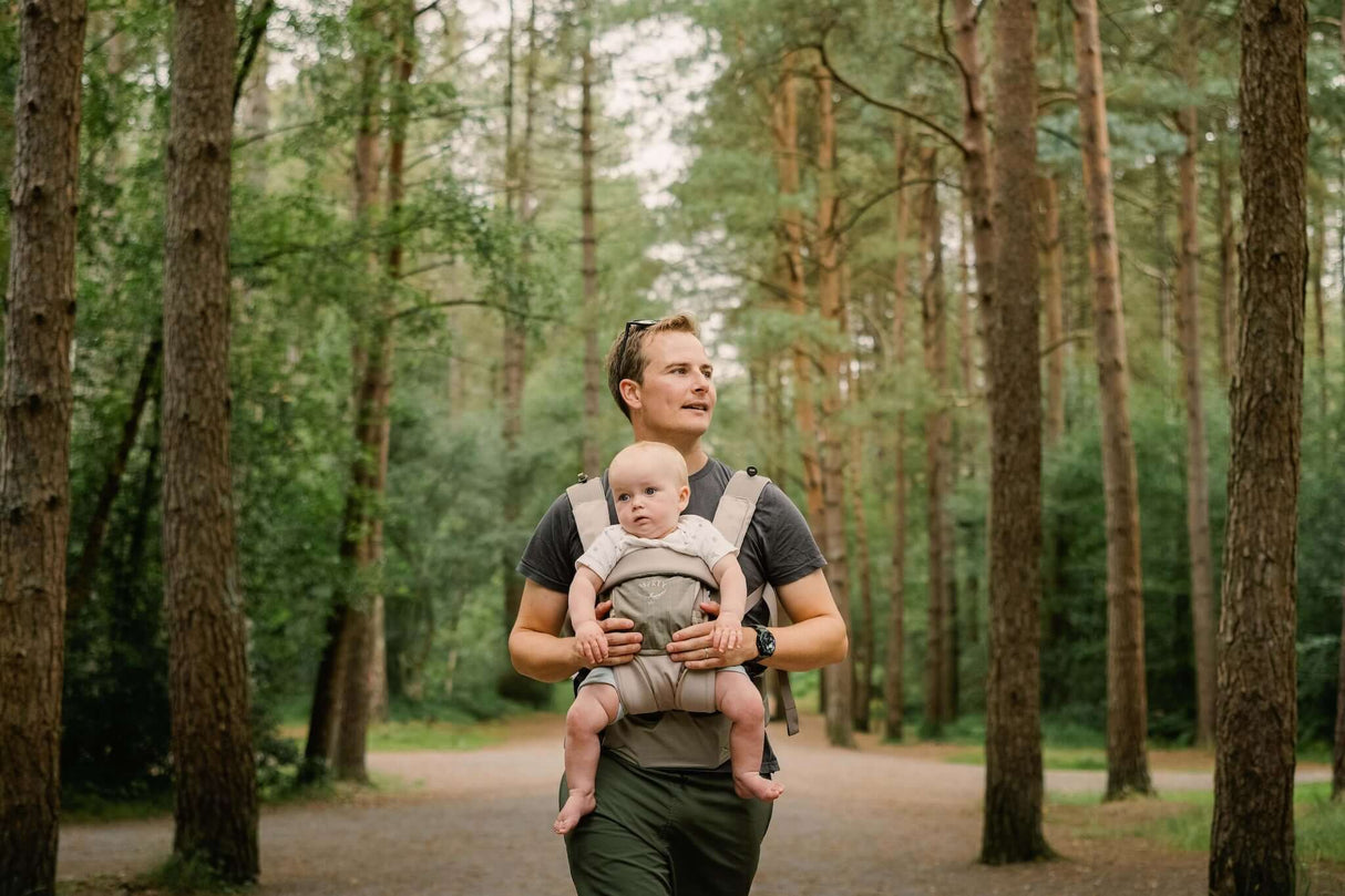 Osprey Poco Soft Child Carrier LT - Tan Concrete in use by a parent carrying a baby in a forest setting | Babymaxi