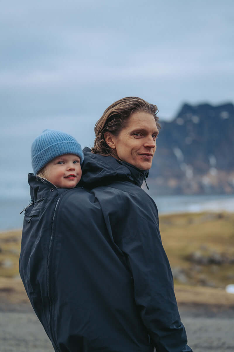 Mamalila Explorer Dad Waterproof Babywearing Shell Jacket - Black in use, dad carrying baby outdoors | Babymaxi