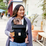 Ergobaby Adapt SoftTouch Cotton - Onyx Black baby carrier worn by a mother holding her baby, perfect for comfort and support | Babymaxi