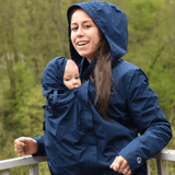 Mamalila Dublin Babywearing Coat – Navy in use by a smiling mother with a baby, showcasing its stylish and functional design | Babymaxi