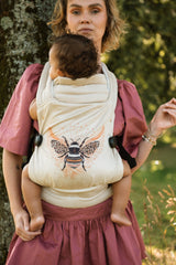 Woman wearing Nomad Air Hexa Bee baby carrier with toddler in outdoor garden environment demonstrating comfort