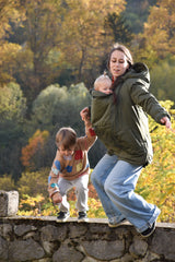 Mamalila Boston Babywearing Jacket Olive, active mom carrying baby while playing outdoors with toddler