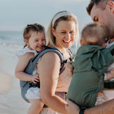 Family enjoying a beach day with Quokkababy E-Carrier - Blue Vibes, ergonomic baby carrier for all stages | Babymaxi
