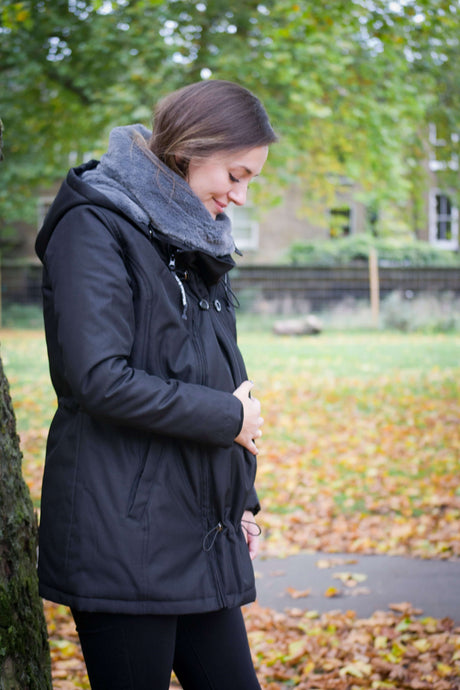Wombat & Co. London - Wallaby Babywearing Jacket – Black & Charcoal worn by a woman in an autumn park | Babymaxi