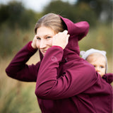 Mamalila Softshell Babywearing Jacket Allrounder Fit Burgundy, mom with baby in back carry pulling up the hood